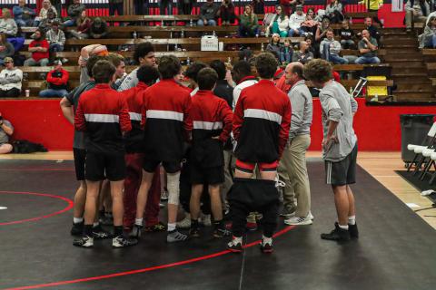 The Mat Dogs gather around head coach Jared Rector to discuss strategy during a match last season at Stephens County High School. LANCE MCCURLEY/Staff