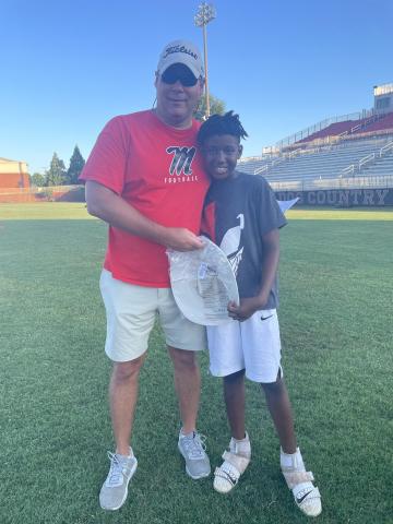 Morgan County head football coach Clint Jenkins (left) with camper Markei Peaks (right) after he won the camp MVP award on day one. CONTRIBUTED
