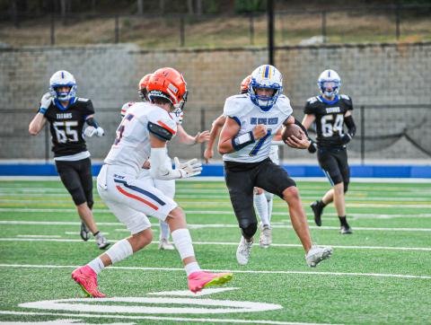 Titans' quarterback Ike O'Neal rushes past Lakeview Academy defenders in a scrimmage on Aug. 11. CHARLES JORDAN/Staff