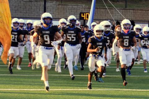 The Lake Oconee Academy Titans run onto the field before the start of their game against Mount Paran Christian in the season opener. (IAN TOCHER/Staff)