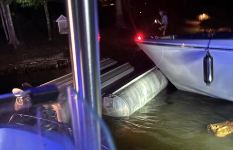 The capsized tritoon is being pushed by Putnam County Sheriff’s boats to the shore after a fireworks show on Lake Oconee July 4. (Contributed)