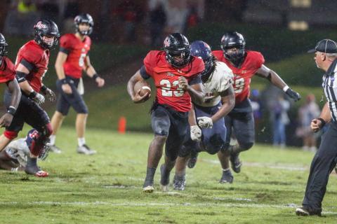 Christian Monfort (23) runs past defenders, rumbling his way down the field toward the end zone. LANCE McCURLEY/Staff