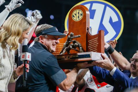 Georgia head coach Kirby Smart holds up the 2025 SEC Championship trophy after the Bulldogs knocked off Alabama 28-7 at Mercedes-Benz Stadium Dec. 6. LANCE MCCURLEY/STAFF