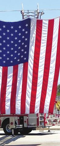 A huge American flag sways in the breeze against a blue sky, provided by Putnam County Fire Department for the veterans ceremony at Harbor at Harmony Crossing Assisted Living. CONTRIBUTED
