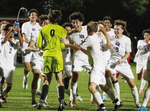 Lake Oconee Academy keeper Knox Van Mol (0) celebrates with teammates after scoring the game-solidifying goal in penalty kicks on Thursday, April 3, against North Oconee. LANCE McCURLEY/Staff