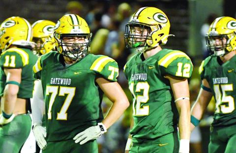 Gatewood juniors Drew Burke (77) and Sean Bennett (12) share a moment during a break in play against Augusta Prep last month at Sammons Field in Eatonton. IAN TOCHER/File photo