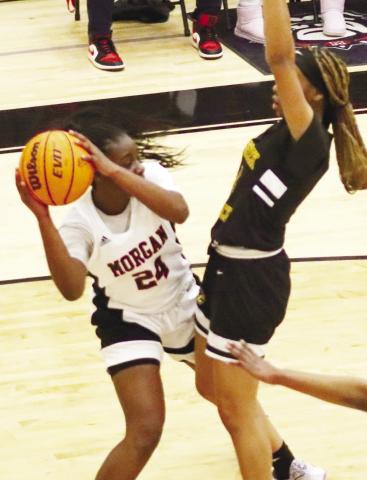 Morgan County freshman Cydney Burke (24) tries to pass the ball around a Cross Creek defender in Friday night’s loss to the No. 8 Lady Razorbacks. LANCE McCURLEY/Staff