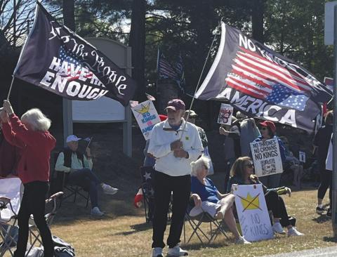 Protestors wave flags at the No Kings rally last Saturday in Greensboro. T. MICHAEL STONE/Staff