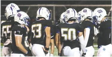 Mason Salemi (50) and Logan Davis (53) listening in the huddle with teammates for the play call during a game earlier this month. BRENDAN KOERNER/Staff