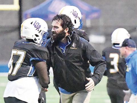 Lake Oconee Academy head coach Patrick Stewart talks with freshman defensive tackle Akeem Redd (57) during a timeout in a game against Brentwood Academy earlier this season. FILE PHOTO