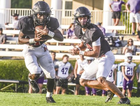 Morgan County running back Jaydon Dorsey (left) takes a handoff from quarterback Talan Fuller (right). LANCE McCURLEY/Staff