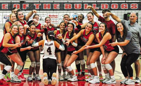 The Morgan County volleyball team takes a photo after beating Pike County on Tuesday, pointing at senior Camryn Scherer, who wears the No. 4, signaling they’re moving on to the semifinals. CHARLES JORDAN/Staff