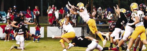 Gatewood’s Evan Bennett (7) leaps forward to successfully block a point-after-touchdown attempt by Briarwood kicker Trey Cotton. (Ball is directly behind the shoulders of Jackson Hewatt (3). DAWN SINCLAIR/Contributed