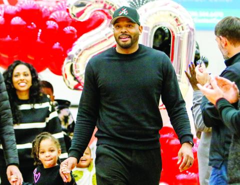 Former Morgan County basketball player B.J. Elder walks the red carpet out to midcourt with his family. LANCE McCURLEY/Staff