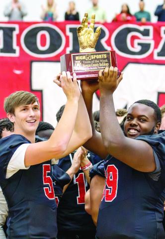 Morgan County seniors and football co-captains Davis Strickland (left) and Ja’mari Mundy hoist the Team of the Week trophy high, signifying the team’s selection by Fox 5 Atlanta’s “High 5 Sports” show. SKYLA MORRIS/Staff