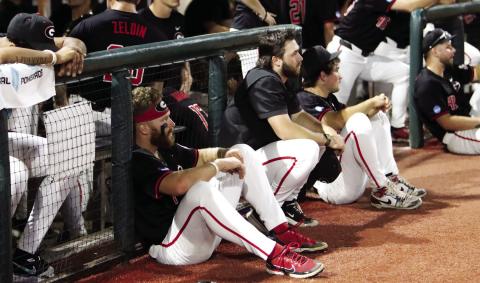 Georgia baseball players sit and watch as N.C. State players celebrate after winning 8-5 on Monday night to advance. LANCE McCURLEY/Staff