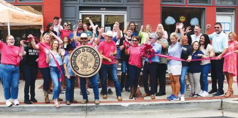 Crooked D Creamery founders and owners David Hodge (center, with scissors) and his wife, Jesse (center, sunglasses), welcomed a sizable crowd of well-wishers May 28 for their official ribbon cutting ceremony at 110 N. Jefferson Ave., in downtown Eatonton. IAN TOCHER/Staff