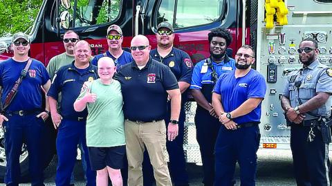 Justin Gilstrap poses with a group of Morgan County first responders Aug. 3, who helped escort him to Monticello in Jasper County to realize his dream of racing a go-cart. CONTRIBUTED