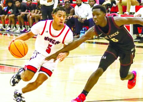 Morgan County senior Reggie Ross (5) drives the lane against Cross Creek guard Quavon Henry (5). LANCE McCURLEY/Staff