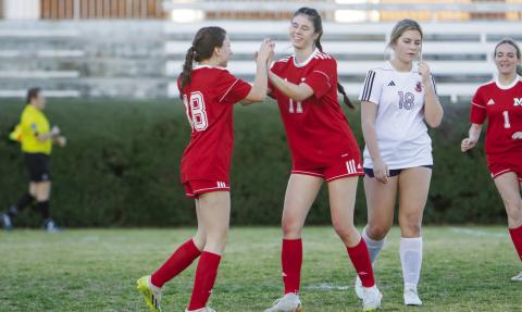 Morgan County seniors Ari Paine (18) and Mia McClain (11) celebrate after a goal during a game against Jackson on March 18. LANCE MCCURLEY/Staff