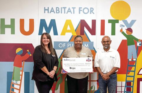 Habitat for Humanity of Putnam Executive Director Murali Thirumal (right) accepts a $48,600 grant check from representatives of Robins Financial Credit Union. CONTRIBUTED