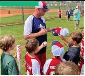 Former Braves pitcher Kevin Millwood signed hats, bats, and balls for several “Fisch campers” last August at the Greene County Recreation Center. CONTRIBUTED