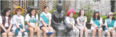 Posing with a statue of Girl Scouts of the USA founder Juliette Gordon Low in the front yard at Low’s birthplace in Savannah, are members of Girl Scouts of Eatonton (l-r): Zoey Robinson, Elizabeth Hensley, Karmen Spillers, Sophia Talavera, Victoria Hensley, Raegan Ogden, Tegan Rainey, and Stormy Kendrick. LENA HENSLEY/Staff