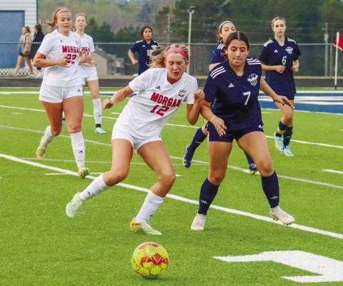 Morgan County senior Morgan McCormack (12) fights off an Apalachee defender for possession of the ball. LANCE MCCURLEY/Staff