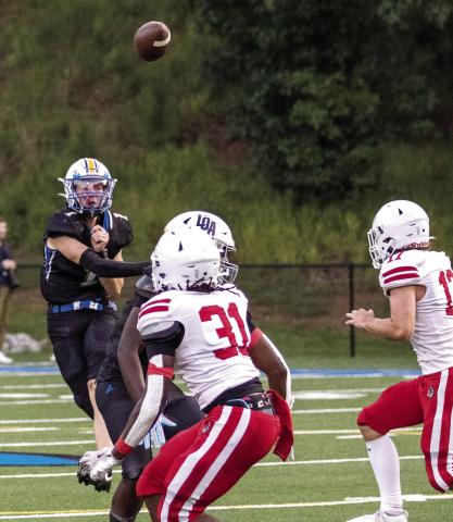 Lake Oconee Academy quarterback Jake McDonald (1) lofts a pass over Social Circle defenders during a scrimmage against the Redskins on Aug. 8. SKYLA MORRIS/Staff