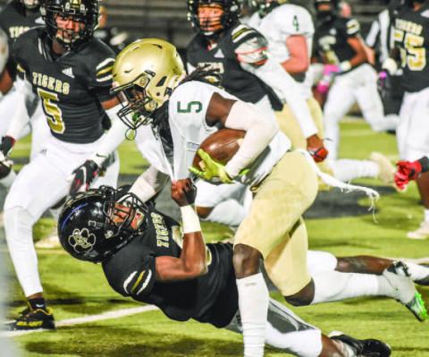 Buddyrow Garner (5) runs through over a Tigers' defender. T. MICHAEL STONE/Staff