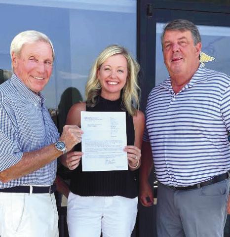 Ralph Olson (left) and Dr. Nic Chronos, founders of Lake Country Medical Aid for Ukraine, _ank Kimberly Liebowitz of Connect and Grow with a copy of their IRS-approved, nonprot status. CONTRIBUTED