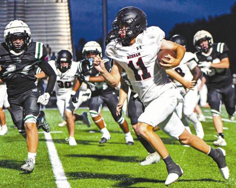Morgan County quarterback Gunner Braswell (11) runs past Walnut Grove defenders. CHARLES JORDAN/Staff