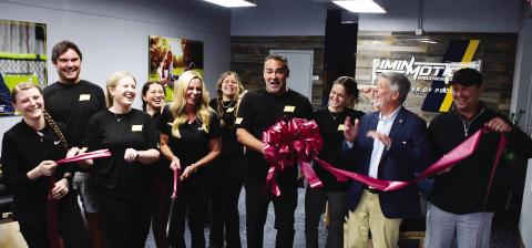 Greene County residents Dana and Dr. Pablo Santamaria (center, with scissors and bow) opened InMotion Wellness initially based on Pablo’s exposure to the benefits of targeted, assisted stretching after undergoing an operation to correct a painful back condition. IAN TOCHER/Staff