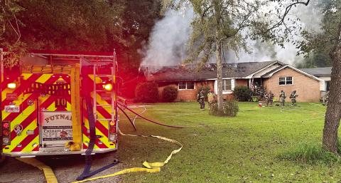 Smoke and flames can be seen on the back of the house as City of Eatonton and Putnam County firefighters begin to battle the blaze. CHIEF WILLIAMSON/Contributed