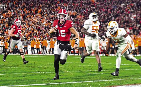 Georgia quarterback Carson Beck (15) races toward the end zone to score a touchdown. CHARLES JORDAN/Staff