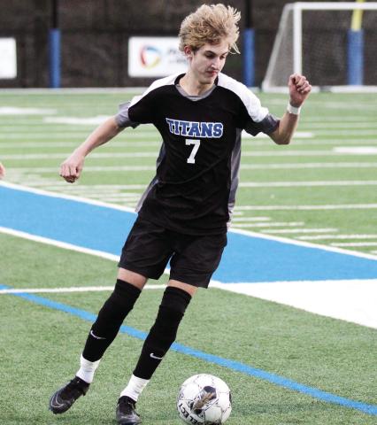 Titans junior Palmer Larkin (7) looks to pass the ball to a teammate against Prince Avenue Christian School last week. WILL MORRISON/Staff