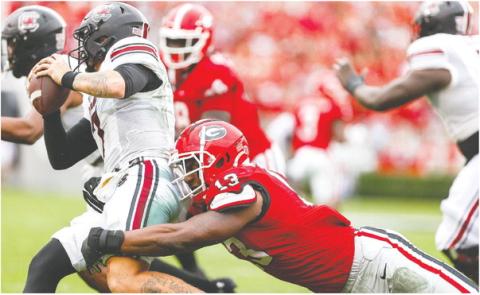 Georgia sophomore edge rusher Mykel Williams (13) brings down South Carolina quarterback Spencer Rattler. TONY WALSH/UGA Athletics