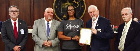 Prior to the start of the Oct. 4 Putnam County Commission meeting, Commission Chairman Bill Sharp (holding frame) invited County Human Resources Director Cynthia Miller to join him and (l-r) Commissioners Daniel Brown, Jeff Wooten, and Stephen Hersey in a proclamation recognizing the month of October as Breast Cancer Awareness Month. (IAN TOCHER/Staff)