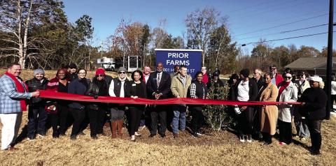 Madison Mayor Fred Perriman (middle) cuts the ribbon, alongside representatives of Woda Cooper Companies Inc. and residents, to celebrate the opening of Prior Farms in Madison. CONTRIBUTED