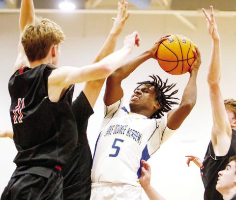 Lake Oconee Academy senior James Wright attempts a tough mid-air shot through a crowd of GMC Prep defenders. LANCE McCURLEY/Staff