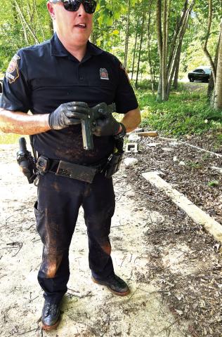 GSP Trooper Alan Rhodes holds the gun recovered from underneath the trailer after PCSO Col. Russell Blenk, EPD Chief Howell Cardwell, PCSO Sgt. Justin Brock and Cpl. Chris Donovan had gone under there and gotten the offenders out. CONTRIBUTED/EPD