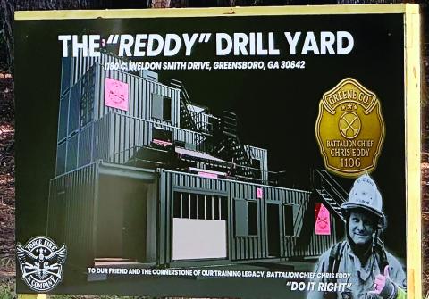 Greene County Fire and Rescue B Shift unveils the sign announcing the planned The Reddy Drill Yard named for Chris Eddy, which will be used for training once completed. HEATHER HARRIS/Staff