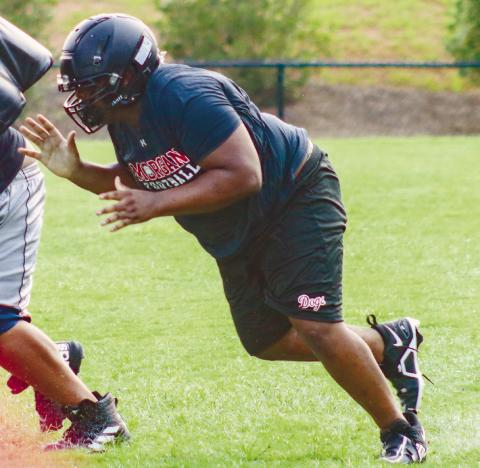 A Morgan County offensive lineman practices hitting a tackling dummy last week in 90-plus degree heat. LANCE McCURLEY/Staff