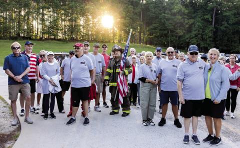 Walkers gather for a photo before making the mile-long walk. LEIGH LOFGREN/Staff