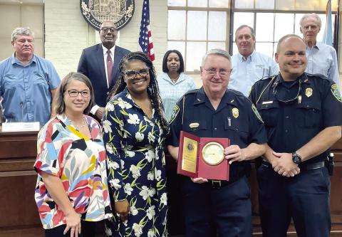 Interim Chief Roy Whitehead receives a token of appreciation from the Madison City Council (l-r Betsy Wagenhauser, Ed Latham, Mayor Fred Perriman, Carrie Peters-Reid, Rick Blanton and Eric Joyce) as well as CFO Karen Stapp and Human Resources Director Karen Robertson. (T. MICHAEL STONE/Staff)