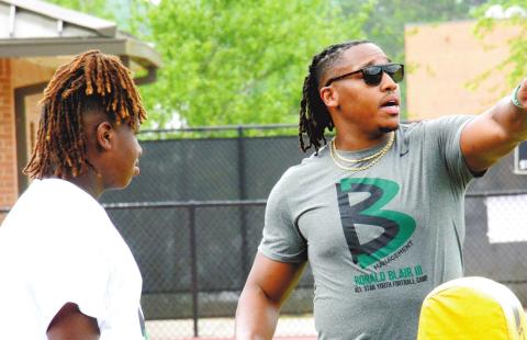 Blair (right) instructs a camp member during last Saturday’s event at Greene County High School. BRENDAN KOERNER/Staff