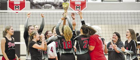 Spike Dog seniors Ally Cox (18) and Emily Hilsman (2) help lift the region championship trophy after defeating ARC in the team's last area match of the season. CHARLES JORDAN/Staff
