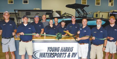 Surrounded by employees new and old, Young Harris Watersports and RVs owner Lance Markham prepares to cut the ribbon. IAN TOCHER/Staff
