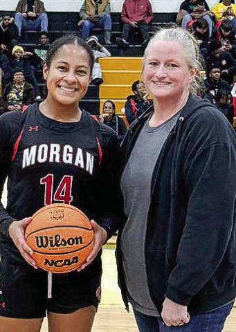 Morgan County senior Jaden Young (left) was presented a game ball with her team’s logo on it after scoring her 1,000th career point in a game against Greene County on Dec. 6. CONTRIBUTED
