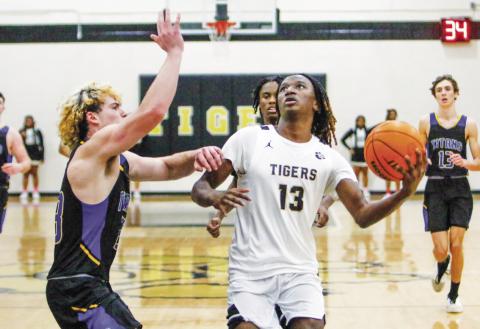 Greene County’s Corey Brown (13) gets set to take a layup over Lake Oconee Academy’s Torin Maddox on Jan. 25. LANCE MCCURLEY/Staff
